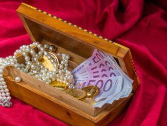 Gold, Schmuck und Bargeld in einer kleinen Truhe